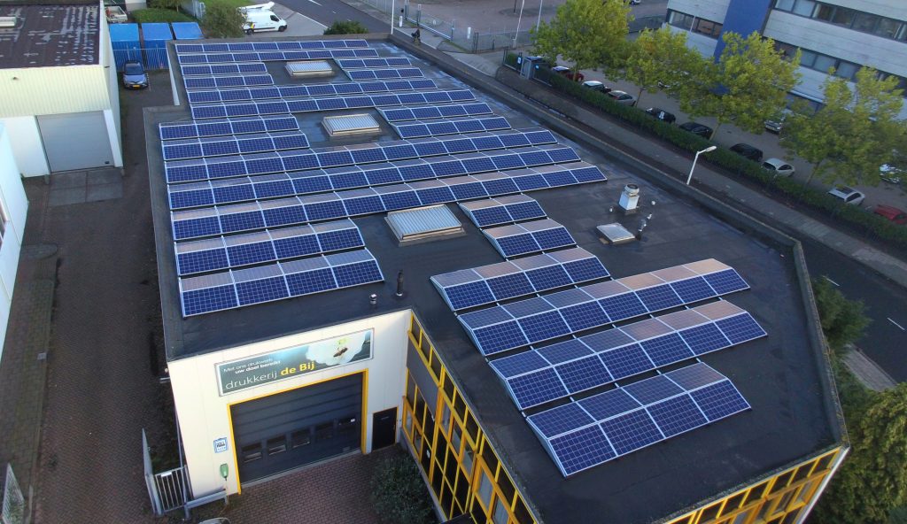 Dak met zonnepanelen op industrieel gebouw.