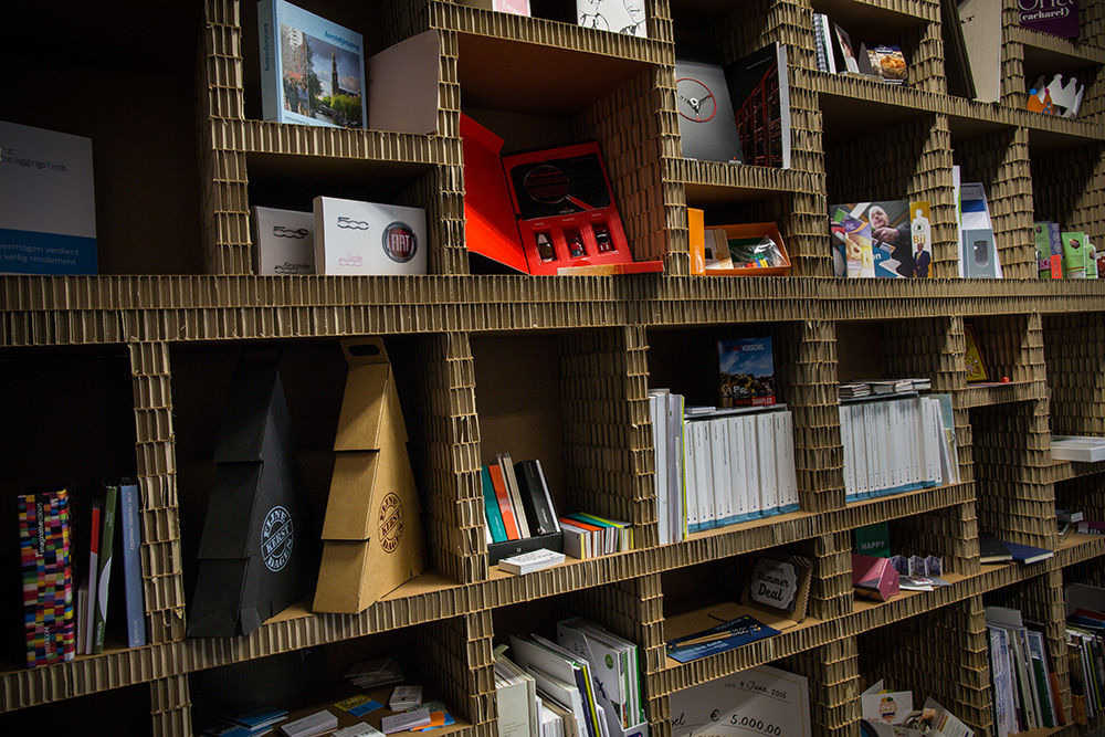 Kartonnen rek met folders en promotieartikelen.